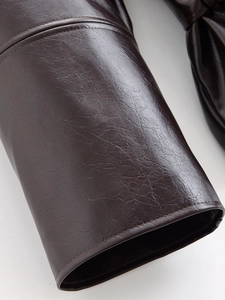 Detailed close-up of dark brown faux leather texture with premium double stitching