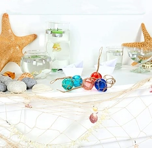 Blue glass nautical float ball with jute rope netting shown with starfish and shells