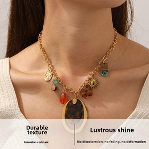 Detail view of Bohemian gold necklace with leopard print discs and sun pendant elements