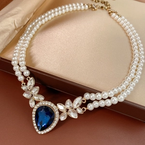 Vue détaillée du collier de perles double épaisseur avec gemme goutte d'eau bleue et coffret