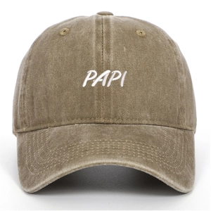 Macro detail of the white PAPI embroidery on a washed khaki cotton baseball cap
