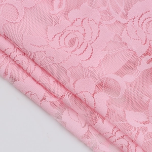 Detaillierte Makroaufnahme von rosa Spitzenstoff mit zarten Rosenblüten-Mustern