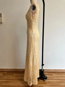 Detail of yellow lace splicing and slim fit mermaid hem on a formal backless dress