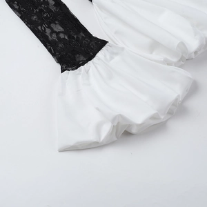 Dettaglio di pizzo floreale nero e tessuto bianco con cuciture ondulate rifinite
