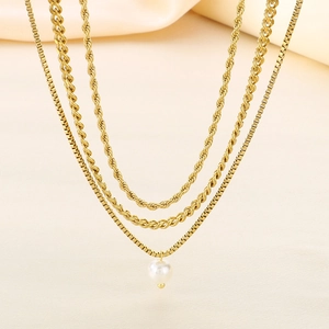 Close-up of triple-layered gold necklaces with rope chain and white pearl pendant