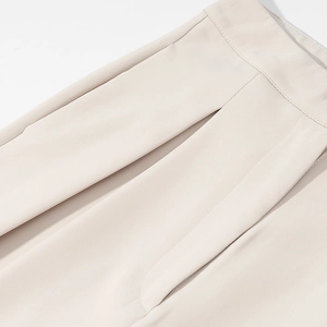 Detailweergave van de taille-stiksels en zijzakken op de minimalistische abrikoos broek