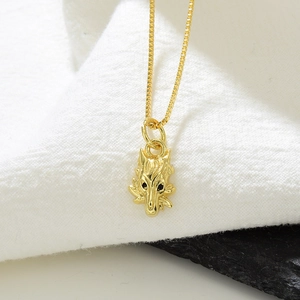 18k gold plated wolf pendant necklace with black zircon eyes on white fabric background
