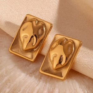 Detailed macro view of gold 18K plated rectangular earrings with embossed 3D design