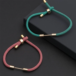 Detail of adjustable woven cord bracelet with gold sliders and textured fiber weave