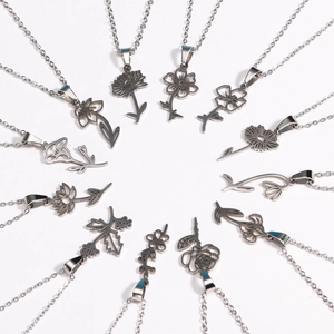 Macro shot of twelve silver stainless steel necklaces with various flower pendant designs