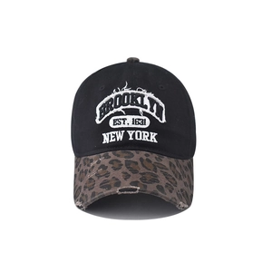 Détail de la broderie Brooklyn et visière léopard sur une casquette en coton noir délavé