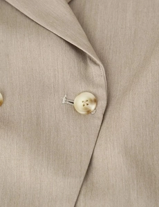 Macro detail of beige blazer lapel with textured fabric and marble resin button