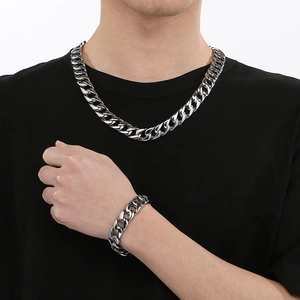 Close-up of 15mm silver stainless steel Cuban link necklace and bracelet set on model