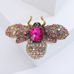 Close-up of gold-tone bee brooch with pink rhinestones and fuchsia gemstone detail