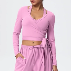 Pink yoga set featuring cross-tie long sleeve top and drawstring leggings detail