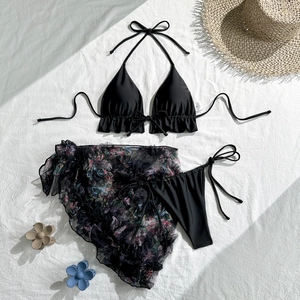 Detailed flat lay of three-piece black bikini set with floral mesh skirt and S size label