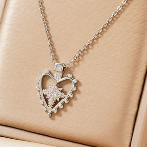 Silver heart pendant necklace with star-shaped zircon on a champagne silk jewelry box