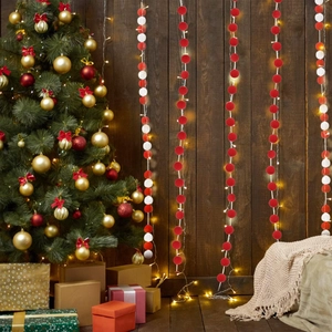 Cozy holiday scene with red and white felt ball garland and warm LED lights