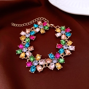 Detailed macro view of a vintage gold floral bracelet with colorful gemstones and lobster clasp