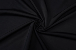 Macro detail of the high-quality black fabric texture with natural light and soft drapes