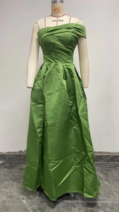 Detail of green satin evening dress featuring pleated bodice and high slit design