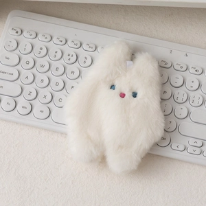 Gros plan du porte-monnaie lapin en peluche blanc avec broderies bleues et roses