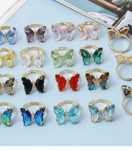 Macro shot of colorful crystal butterfly rings in golden adjustable settings