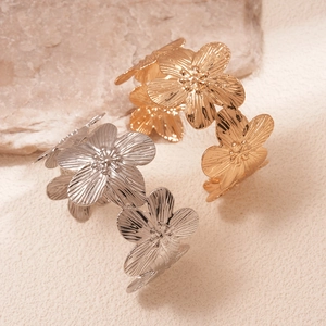 Golden and silver metal flower open bracelets with textured petals in a luxury set