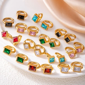 Macro shot of assorted gold hoop earrings with multi-colored emerald-cut zircon gems