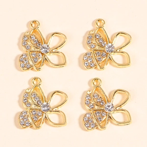 Macro detail of four gold butterfly pendants with sparkling rhinestones for DIY jewelry