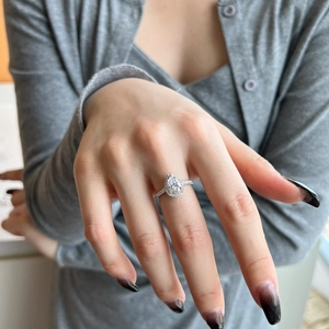 Classic pear shaped S925 sterling silver ring with halo diamonds on a hand