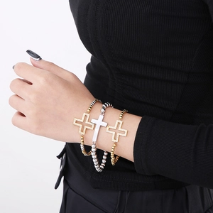 Gros plan de bracelets croix en acier inoxydable avec strass sur un poignet féminin