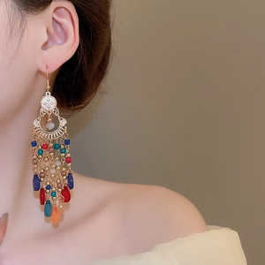 Detail shot of bohemian tassel earrings with colorful beads and gold ethnic teardrop charms