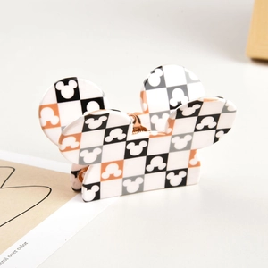 Detail of Mickey Mouse silhouette on orange and black checkered hair claw clip