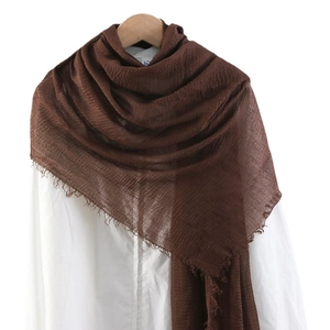 Brown crinkled cotton linen scarf with frayed edges displayed on a white shirt