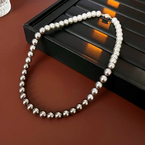 Detail of gradient pearl necklace from white to dark grey on black jewelry tray