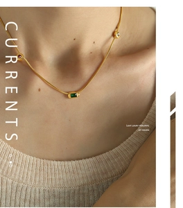 Close-up of elegant gold collar necklace with green square zircon pendant on model