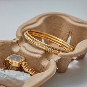 Detail of gold-plated zircon bangle with three-layer design next to a vintage square watch