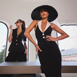 Detail of elegant black halter dress featuring a contrasting white collar and button accents