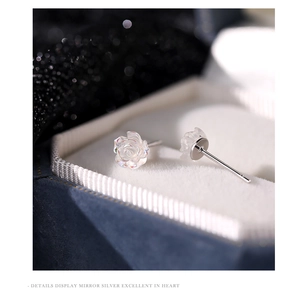 Macro shot of iridescent white rose studs in a jewelry box with detailed silver pins