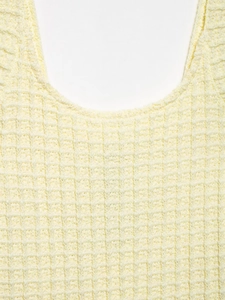 Primer plano de la textura de punto tipo gofre en un vestido de verano amarillo
