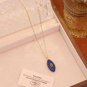 Détail du pendentif ovale rétro en lapis-lazuli sur une chaîne dorée en acier inoxydable