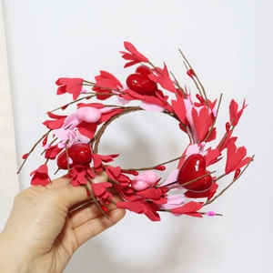Détail d'une couronne de jasmin en forme de cœur avec baies rouges et feuilles de mousse