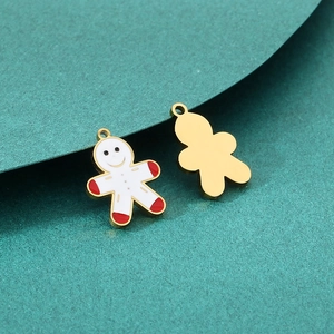 Détail macro de pendentifs bonhomme de pain d'épices montrant le dos doré et l'émail