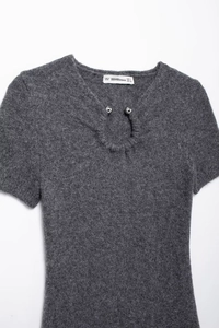 Close-up of dark grey knit dress featuring keyhole neckline and metal button details