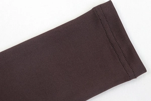 Detail of dark brown yoga set sleeve showing tight knit fabric and durable double stitching