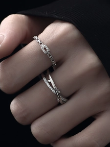 Detailed close-up of layered minimalist silver rings with sparkling diamond accents