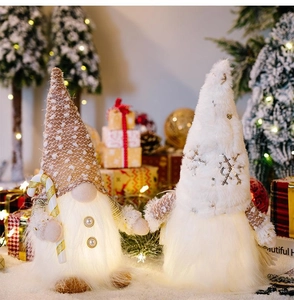 Close-up of glowing plush Christmas gnomes with warm LED lights and sequins decor