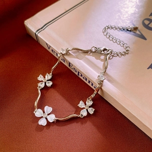 Detail of silver clover bracelet with white cat eye stone and wavy metal links