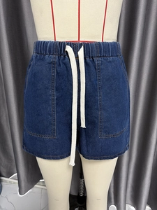 Detail of dark blue denim shorts with elastic waistband and white cotton drawstring